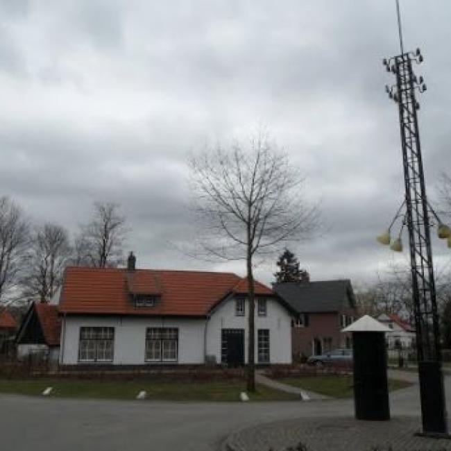 Plein met bakkerij, slagerij, dorpspomp en straatlantaarn